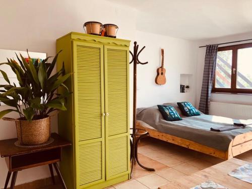a bedroom with a yellow cabinet and a bed at Repülőhal Apartmanház in Zebegény