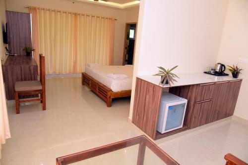 a bedroom with a bed and a small tv at Villa Varkala in Varkala
