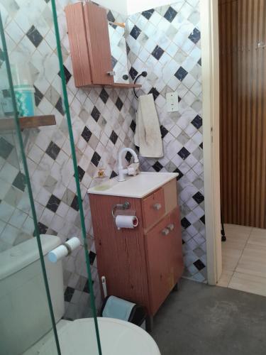 a small bathroom with a sink and a toilet at Quarto suíte in Guaratuba