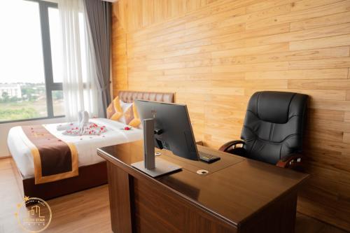 a bedroom with a desk with a computer and a bed at LuckyStar Hotel in Pleiku
