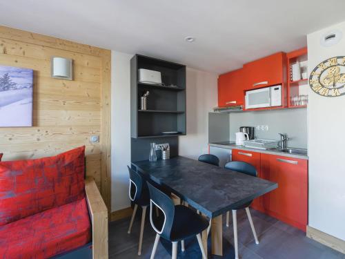 une cuisine avec un canapé rouge et une table à manger dans l'établissement Charmant 2 Pièces Rénové Proche Pistes avec Balcon et Espace Bien-être - FR-1-181-2281, à La Plagne Tarentaise