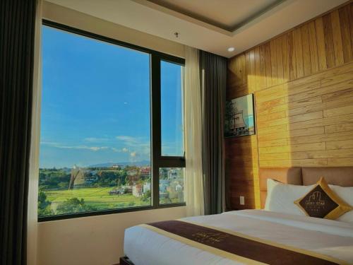 a bedroom with a bed and a large window at LuckyStar Hotel in Pleiku