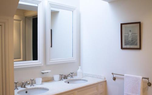 a bathroom with two sinks and a large mirror at Guest house La Maison Chantecler in Brussels
