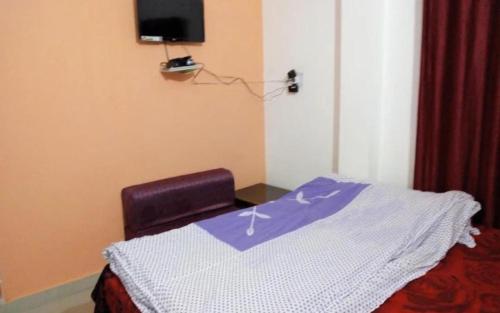 a room with a bed and a chair and a tv at Himalayan Villa by StayApart in Phata