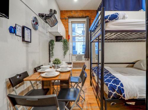 a small room with a dining table and bunk beds at Metropolitan Studio Apartments Manhattan in New York