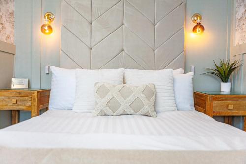 a bedroom with a white bed with a large headboard at The Blackhorse Accommodation in Newton Stewart