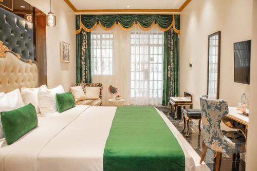 a bedroom with a large bed and a desk at Muthu Sovereign Suites & Spa, Limuru Road, Nairobi in Limuru