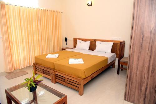 a bedroom with a bed with two towels on it at Villa Varkala in Varkala