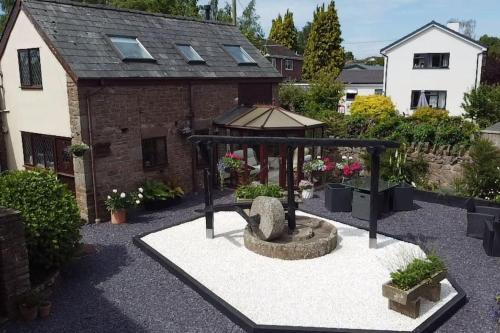 a garden with a fountain in front of a building at Rose Cottage Wye Valley AONB in Llangarren