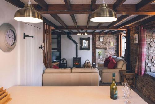 a room with couches and a table with a bottle of wine at Rose Cottage Wye Valley AONB in Llangarren
