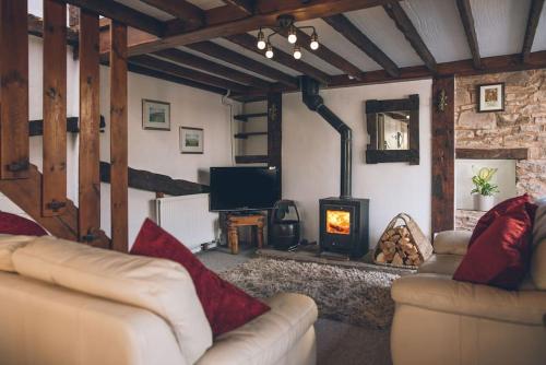 a living room with a couch and a wood stove at Rose Cottage Wye Valley AONB in Llangarren