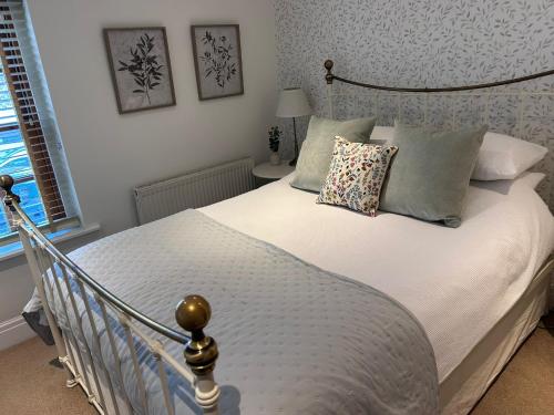 a bedroom with a large white bed with pillows at Harbour Cottage, Conwy in Conwy