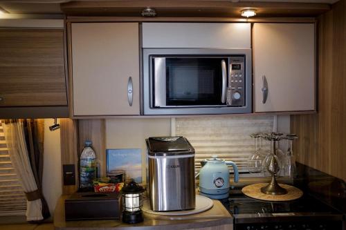 a kitchen with a microwave and a counter top at Sterling seastar ที่พักติดชายหาด วิวทะเล in Ban U Taphao