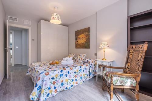a bedroom with a bed and a chair at Luxury suite Reino de Granada in Granada