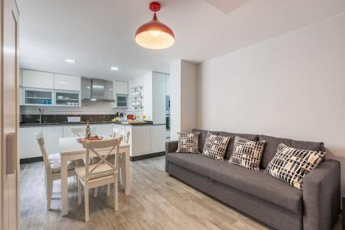 a living room with a couch and a table and a kitchen at Luxury suite Reino de Granada in Granada