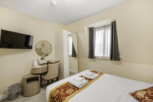 a hotel room with a bed and a desk at Drake Hotel Plymouth in Plymouth