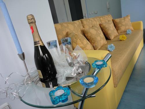 een fles wijn op een glazen tafel voor een bank bij Accommodation JT Old Town Historical sites in Ohrid
