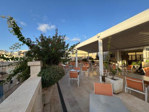 a patio with chairs and tables on a building at The Maltese Sun in Sliema