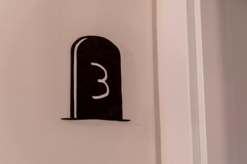 a black object with the number three on a wall at Hotel Rural La Bodega del Baldomero in San Esteban de Gormaz