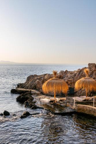 a group of chairs and umbrellas on the beach at Hotel de Mar Gran Meliá - Adults Only - The Leading Hotels of the World in Illetas