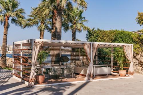 a patio with a gazebo with palm trees at Hotel de Mar Gran Meliá - Adults Only - The Leading Hotels of the World in Illetas