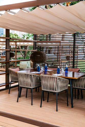 a patio with wooden tables and chairs on a deck at Hotel de Mar Gran Meliá - Adults Only - The Leading Hotels of the World in Illetas