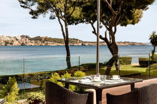 a table and chairs with a view of the ocean at Hotel de Mar Gran Meliá - Adults Only - The Leading Hotels of the World in Illetas