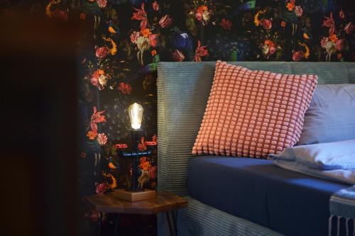 a bed with a pillow and a table with a lamp at Gästehaus Villa Wolff in Bomlitz