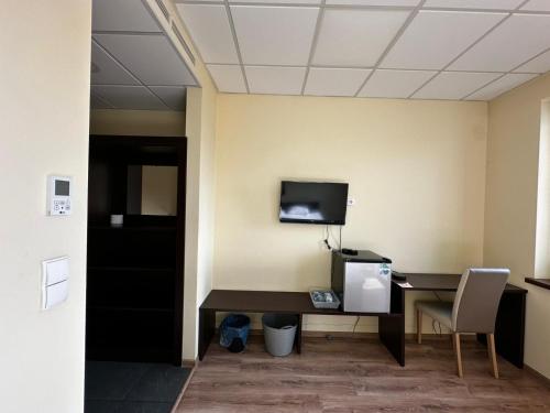 an office with a desk and a tv on a wall at HONGANE GUEST HAUS & korean restaurant in Żory