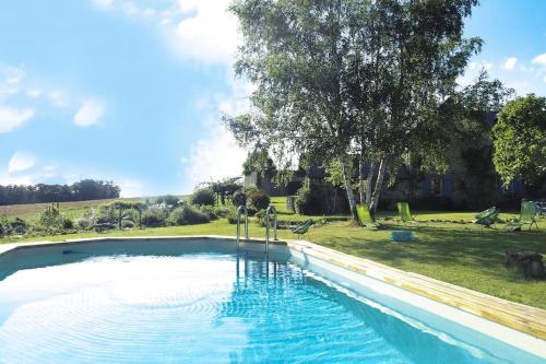une grande piscine dans une cour avec un arbre dans l'établissement Maison Millagé face aux Pyrénées, à Oloron-Sainte-Marie
