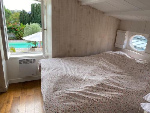 a bedroom with a bed and a large window at un séjour de rêve au calme rétaise in Sainte-Marie-de-Ré