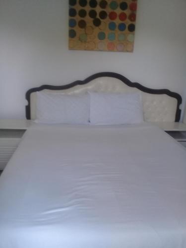 a bed with white sheets and pillows in a bedroom at Accoustix Backpackers Hostel in Johannesburg