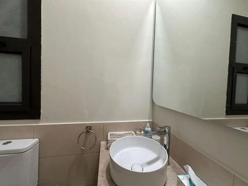 a bathroom with a white toilet and a mirror at Stylish 1BR Ground With Free Pool & Lagoon Access In Gouna in Hurghada