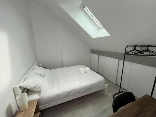 - une petite chambre blanche avec un lit et des draps blancs dans l'établissement Le Bois Lumineux - T2 proche de la Gare, à Cambrai
