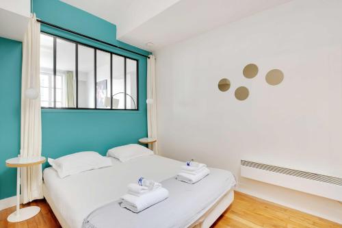 - une chambre avec un lit blanc et un mur bleu dans l'établissement Charming apartment - 1BR-6P - Sentier, à Paris