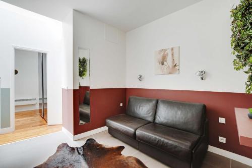 - un salon avec un canapé en cuir et un miroir dans l'établissement Charming apartment - 1BR-6P - Sentier, à Paris