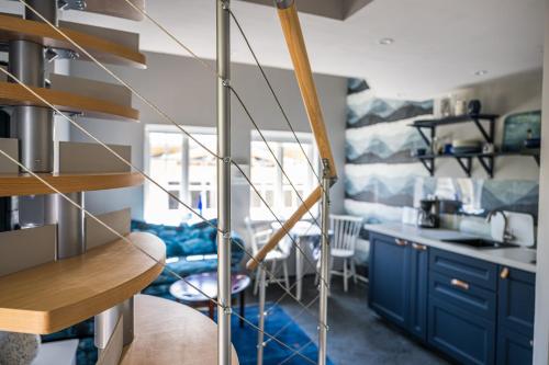 a kitchen with blue cabinets and a spiral staircase at Boråkra Bed & Breakfast in Karlskrona