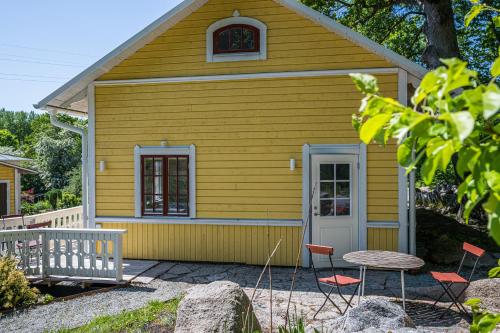 a small yellow house with a table and chairs at Boråkra Bed & Breakfast in Karlskrona