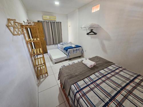 a room with two beds and a chair in it at Sol & Vento Chalés - Chalé Tourinhos com piscina privativa in São Miguel do Gostoso