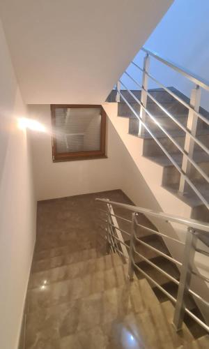 a staircase in a house with a glass railing at Apartment Andrin in Gostivar