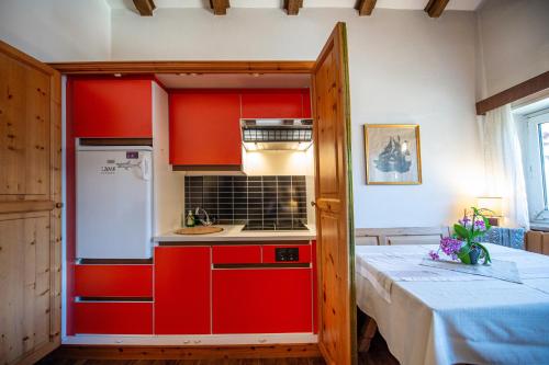 a small kitchen with red cabinets and a table at Apartments Raphael in Ortisei