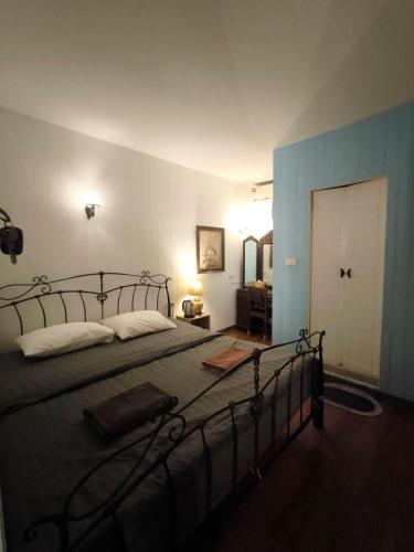 une chambre avec un grand lit et une porte blanche dans l'établissement Bann Chana BKK, à Bangkok