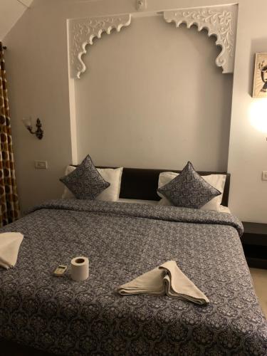 a bed with a book and a napkin on it at Peacock Guest House - Lake View Hotel In Udaipur in Udaipur