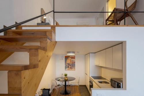 a staircase in a room with a table and a kitchen at Condes de Azevedo Palace Apartments in Porto