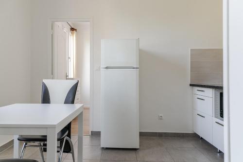 a white refrigerator in a kitchen with a table at Superbe maisonette avec parking privé à Villejuif in Villejuif