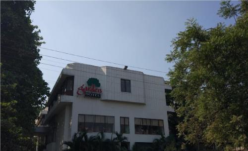a white building with a sign on the top of it at Hotel Garden in Navi Mumbai