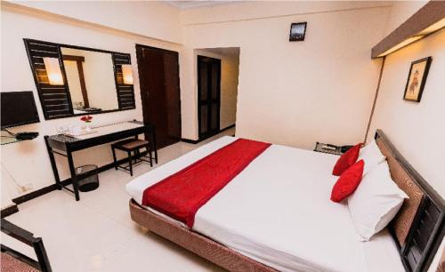 a bedroom with a bed and a desk with a computer at Hotel Garden in Navi Mumbai