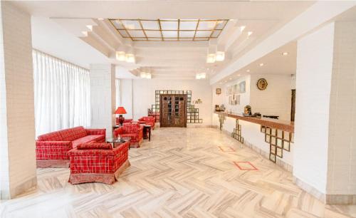 a living room with red couches and a bar at Hotel Garden in Navi Mumbai