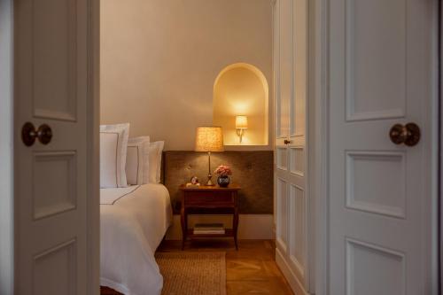 a bedroom with a bed and a table with a lamp at Rosewood Schloss Fuschl in Hof bei Salzburg