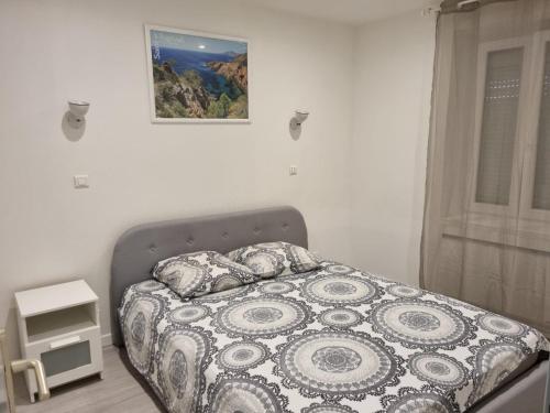 un lit dans une chambre avec un tableau sur le mur dans l'établissement Appartement f2 au bord de mer, à Saint-Raphaël